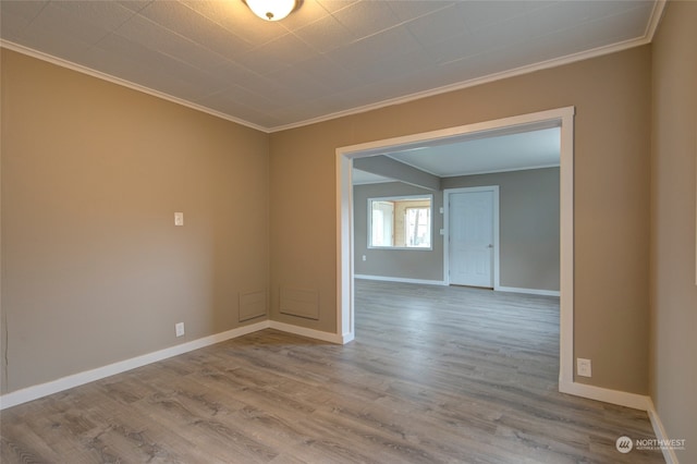 spare room featuring crown molding and wood-type flooring