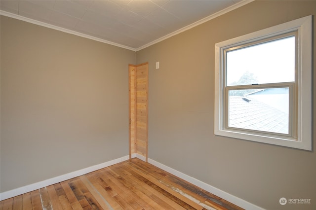 empty room with ornamental molding and hardwood / wood-style floors