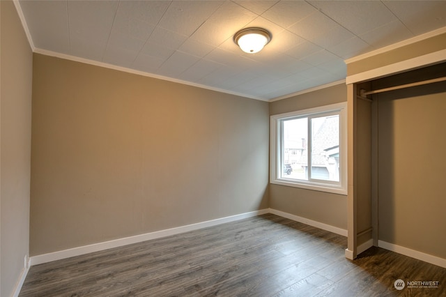 unfurnished bedroom with crown molding, a closet, and dark hardwood / wood-style floors