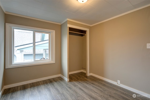 unfurnished bedroom featuring a closet, crown molding, and hardwood / wood-style floors