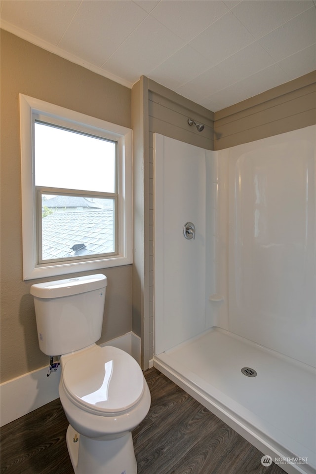 bathroom with walk in shower, crown molding, hardwood / wood-style flooring, and toilet