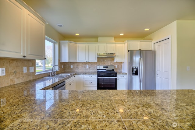 kitchen with tasteful backsplash, appliances with stainless steel finishes, sink, and white cabinets