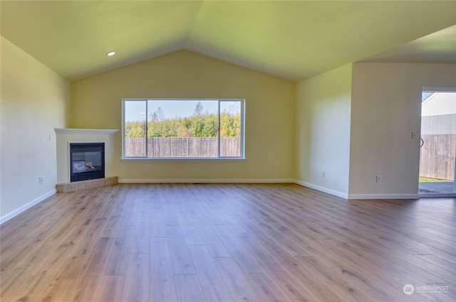 unfurnished living room featuring light wood-type flooring and vaulted ceiling