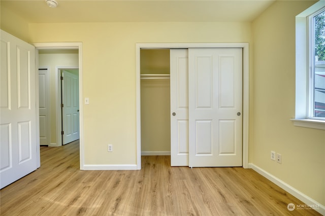 unfurnished bedroom featuring light hardwood / wood-style flooring and a closet