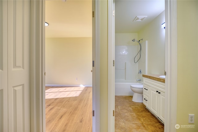 full bathroom featuring vanity, hardwood / wood-style floors, shower / tub combination, and toilet