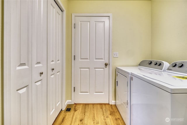 laundry room with washer and dryer and light hardwood / wood-style flooring