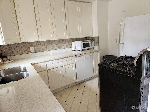 kitchen featuring decorative backsplash, white appliances, and sink