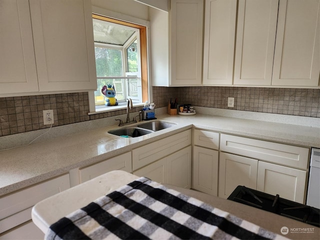 kitchen featuring white cabinetry, decorative backsplash, and sink