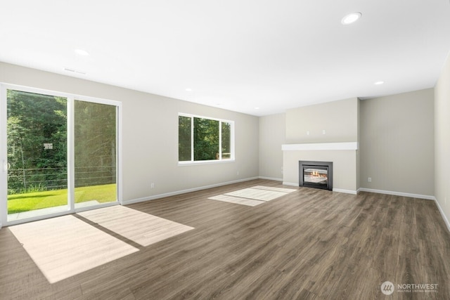 9865 Merrick St SE Unit 384, Yelm, WA 98597 - unfurnished living room featuring wood finished floors, a glass covered fireplace, and recessed lighting
