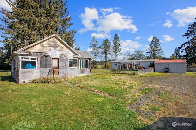 view of front of property with a front yard and an outbuilding