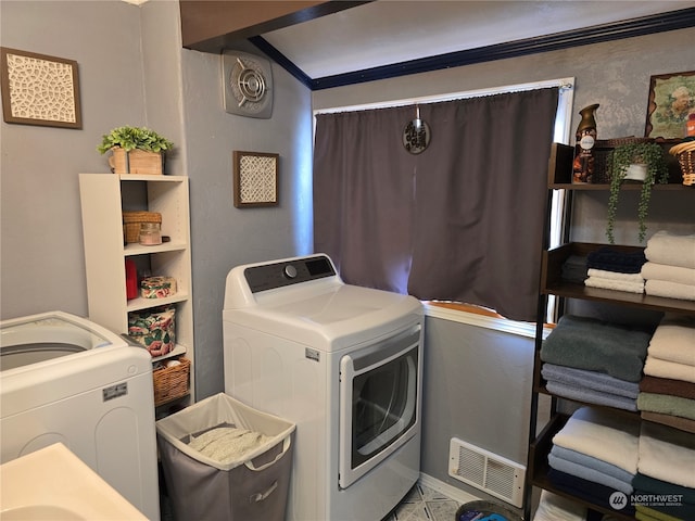 clothes washing area with crown molding and washing machine and dryer