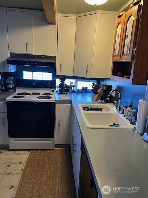 61 Salt Air St, Clallam Bay, WA 98326 - kitchen with electric range oven, a sink, under cabinet range hood, light countertops, and white cabinetry