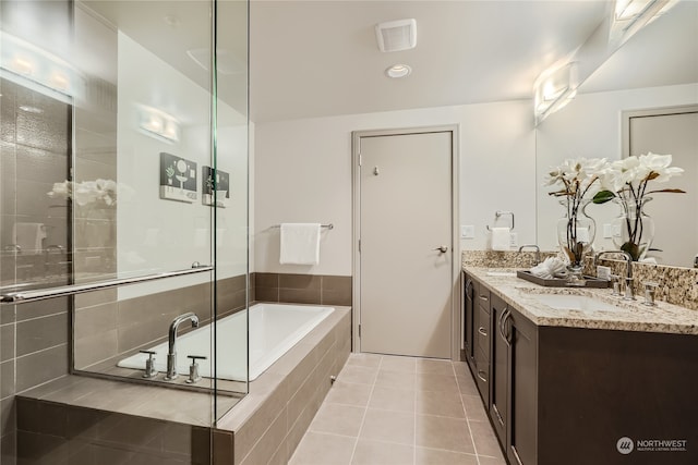 bathroom featuring vanity, tile patterned flooring, and tiled bath