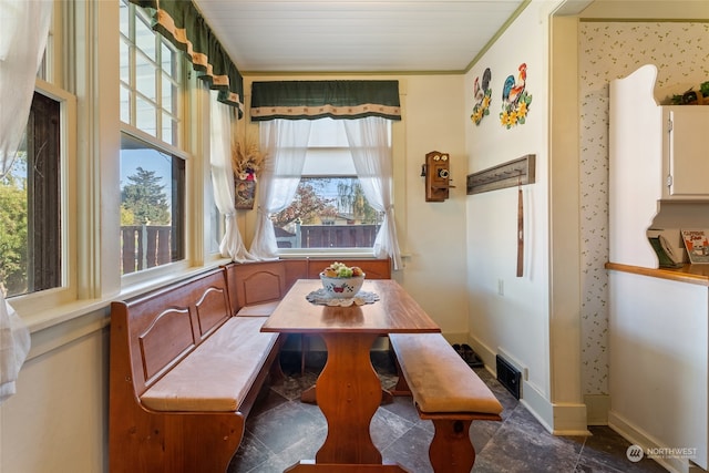 dining area featuring crown molding, breakfast area, and plenty of natural light