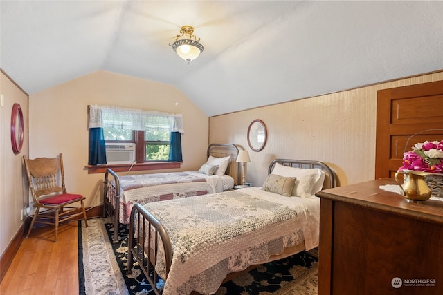 bedroom with lofted ceiling, hardwood / wood-style floors, and cooling unit