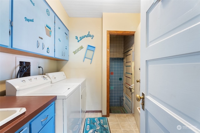 laundry area with sink, light tile patterned floors, cabinets, and separate washer and dryer