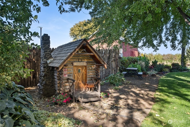 view of front of home featuring a storage unit and a front lawn