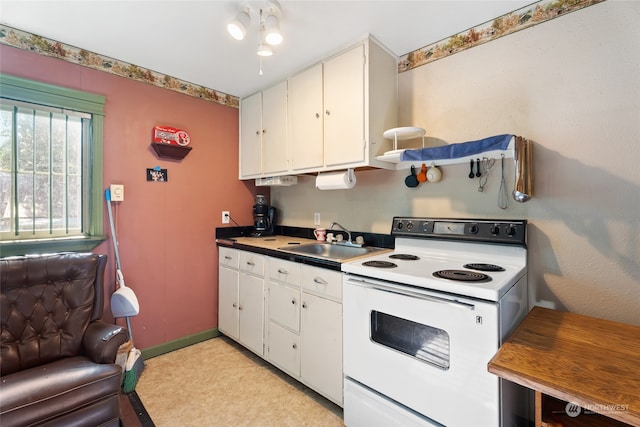 kitchen featuring white electric range, sink, and white cabinets