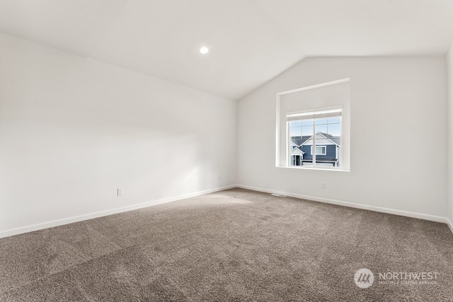 unfurnished room featuring lofted ceiling and carpet flooring