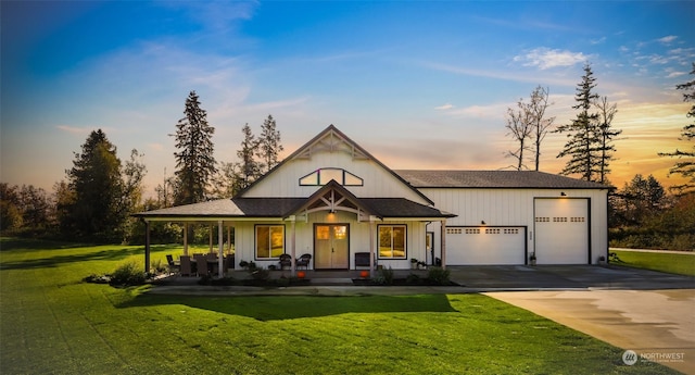 view of front of home with driveway, covered porch, an attached garage, roof with shingles, and a front lawn