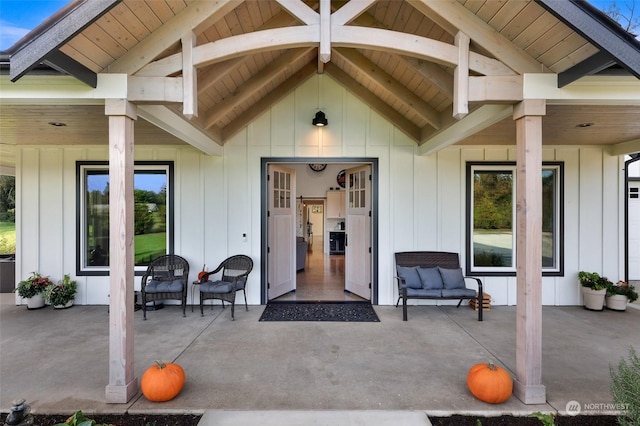 doorway to property with board and batten siding and a patio
