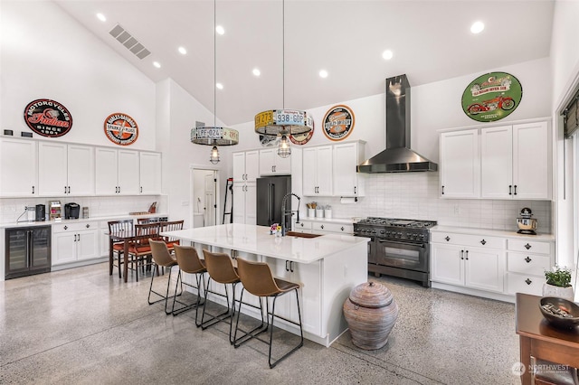 kitchen with a sink, high end appliances, high vaulted ceiling, wall chimney exhaust hood, and wine cooler