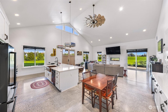 kitchen featuring freestanding refrigerator, light countertops, light speckled floor, and high vaulted ceiling