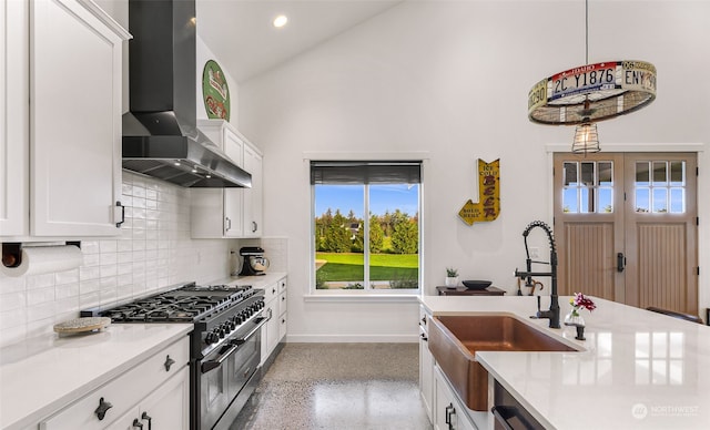 kitchen featuring sink, white cabinetry, wall chimney exhaust hood, decorative backsplash, and double oven range