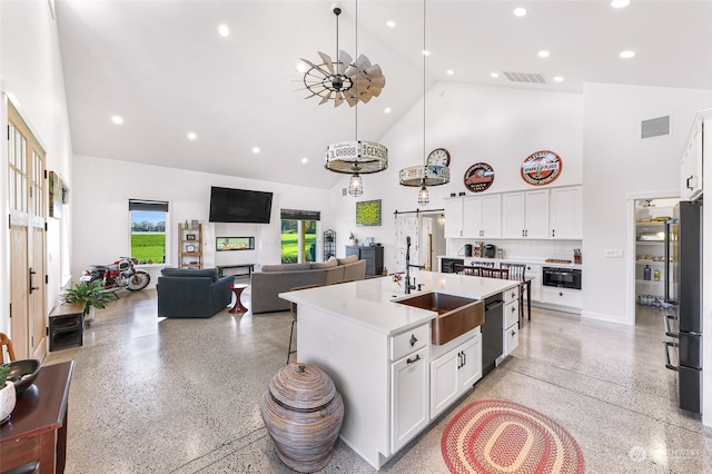 kitchen with an island with sink, white cabinetry, high vaulted ceiling, black appliances, and sink