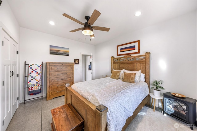 bedroom with baseboards, a wood stove, recessed lighting, and a ceiling fan