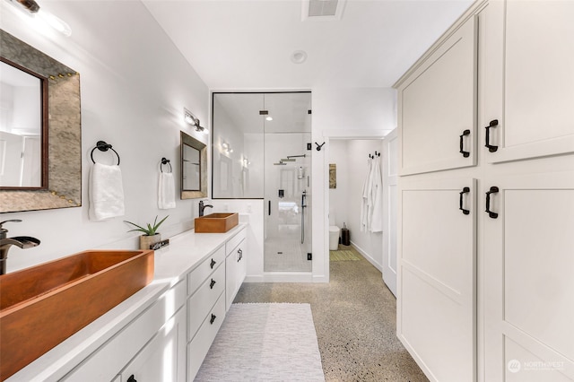 bathroom featuring vanity, walk in shower, and toilet