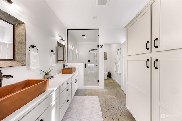 full bath with speckled floor, visible vents, a sink, and a shower stall