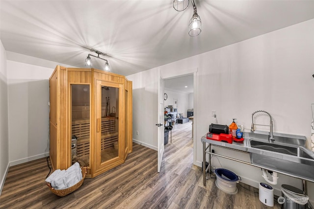 interior space with wood finished floors, baseboards, and a sink