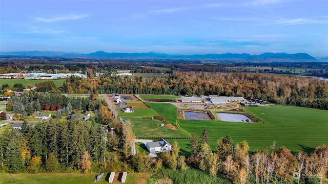 aerial view with a water and mountain view and a wooded view