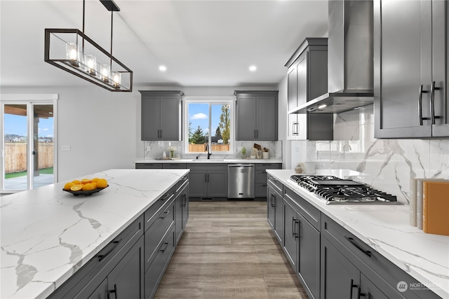 kitchen featuring light hardwood / wood-style floors, decorative light fixtures, plenty of natural light, and gray cabinetry