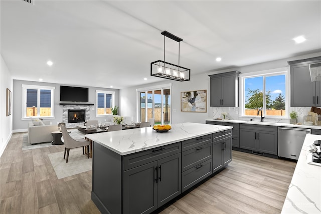 kitchen with gray cabinets, a center island, and stainless steel dishwasher