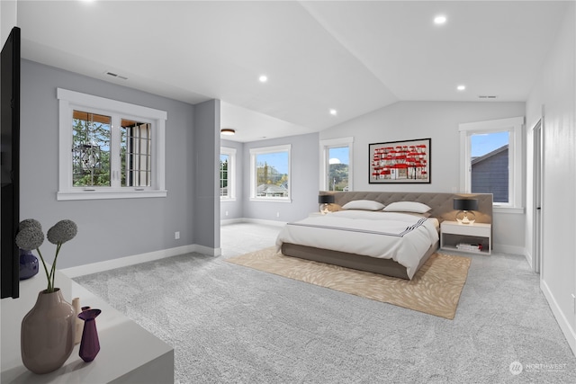 bedroom featuring light carpet, lofted ceiling, and multiple windows