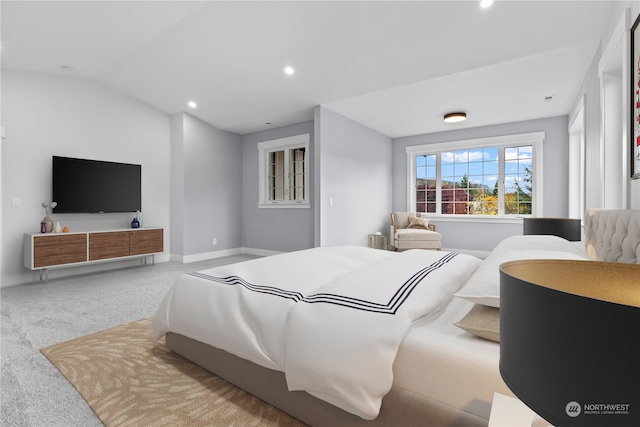 bedroom featuring light colored carpet and vaulted ceiling