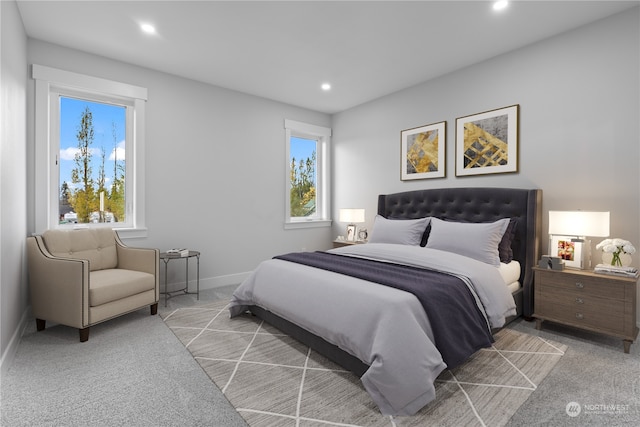 bedroom with multiple windows and light colored carpet