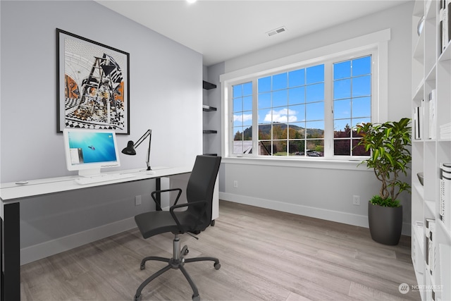 home office with light hardwood / wood-style flooring