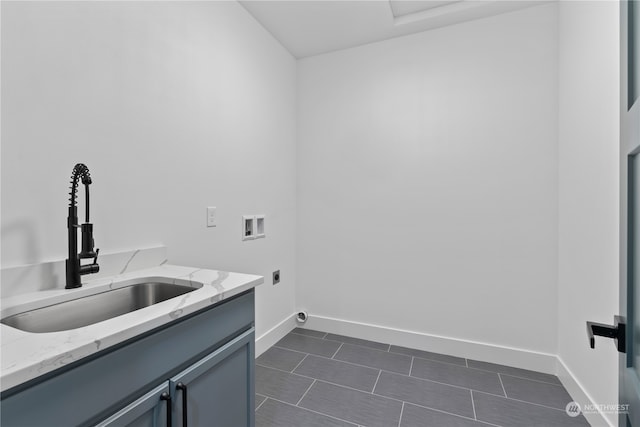 washroom featuring sink, electric dryer hookup, washer hookup, and cabinets