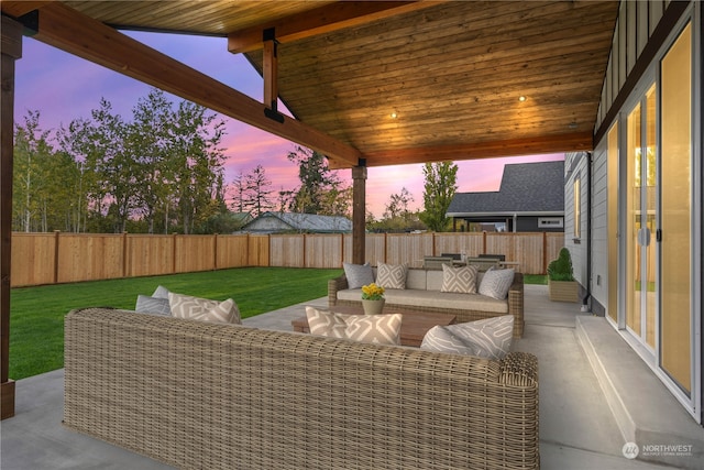 patio terrace at dusk featuring a lawn and an outdoor hangout area