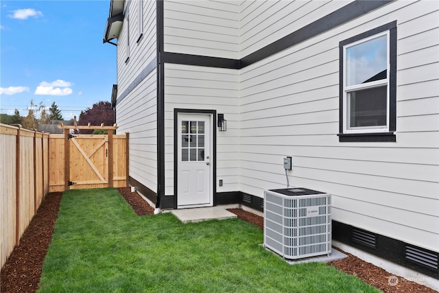 entrance to property with a yard and central AC