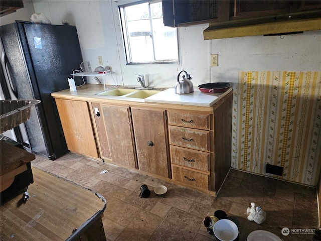 1194 US Highway 12 Unit 18, Montesano, WA 98563 - kitchen featuring stone finish floor, brown cabinetry, a sink, light countertops, and freestanding refrigerator
