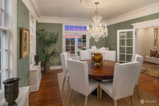 dining space featuring french doors, dark hardwood / wood-style floors, an inviting chandelier, and ornamental molding