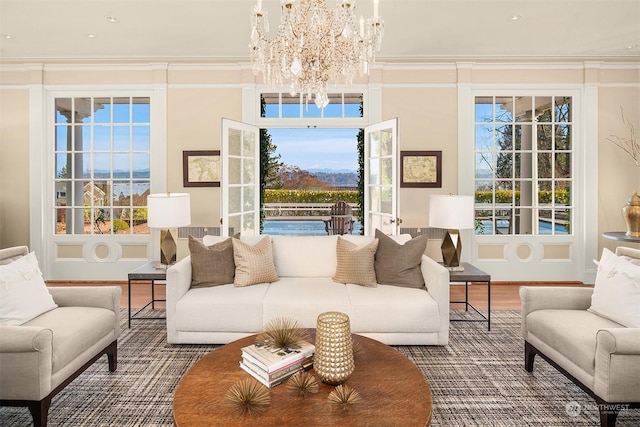 living area featuring hardwood / wood-style floors, ornamental molding, and a chandelier