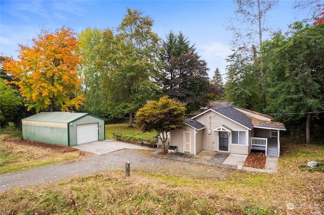 view of front of house featuring a garage and an outbuilding