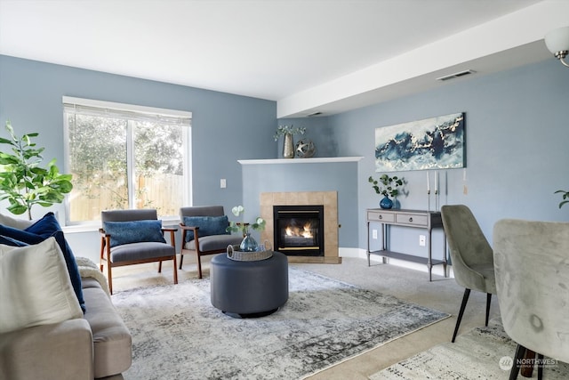 living room with a tiled fireplace and carpet flooring