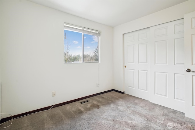 unfurnished bedroom with light carpet and a closet