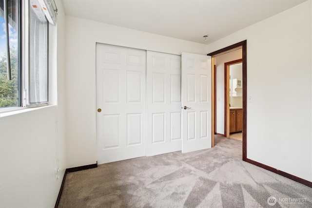 unfurnished bedroom featuring light carpet and a closet